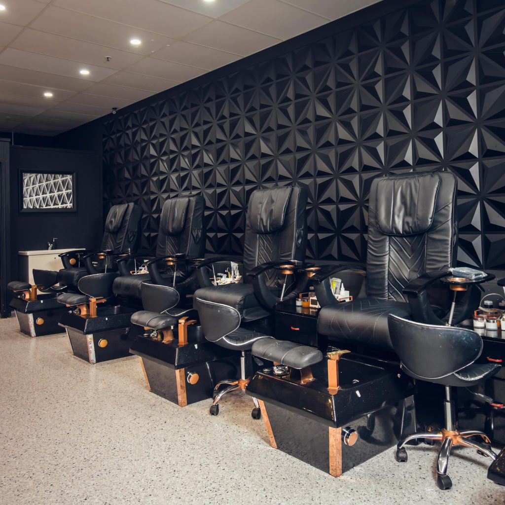 a line of black and rose gold accent Spa pedicure chairs in a clean salon in Hervey Bay